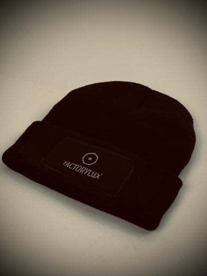 Factorylux black hat with logo front, central. Comfortable, warm, stylish AND made from 100% recycled acrylic waste