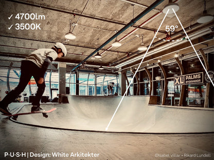 Skateboarders, skating at an indoor skatepark, illuminated by 4700lm 3500K architectural pendant lights