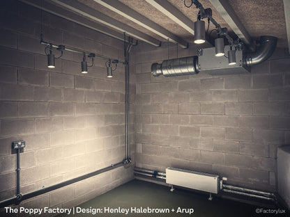 Exposed brutalist stye concrete block walls with HVAC, lighting track and spotlights at the Poppy Factory in Richmond